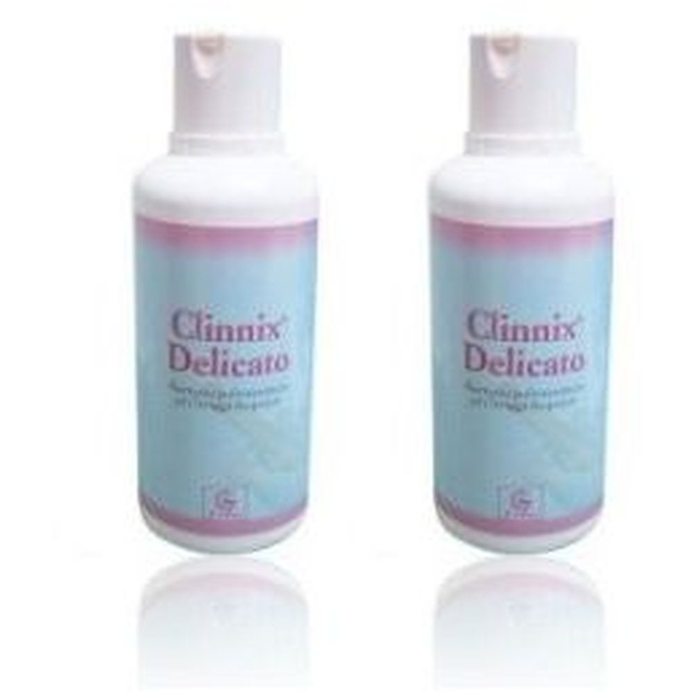 Deux flacons de shampooing Clinnix Delicato. Flacons bleu clair avec bouchons blancs et rayures roses. Inscription Clinnix Delicato.