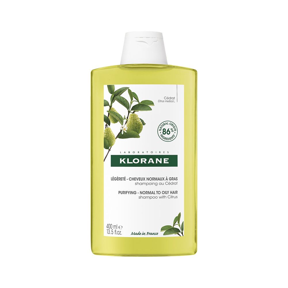 Flacon jaune, bouchon blanc. Inscription Klorane, Shampooing, 400 ml. Illustration de plantes et d'agrumes.