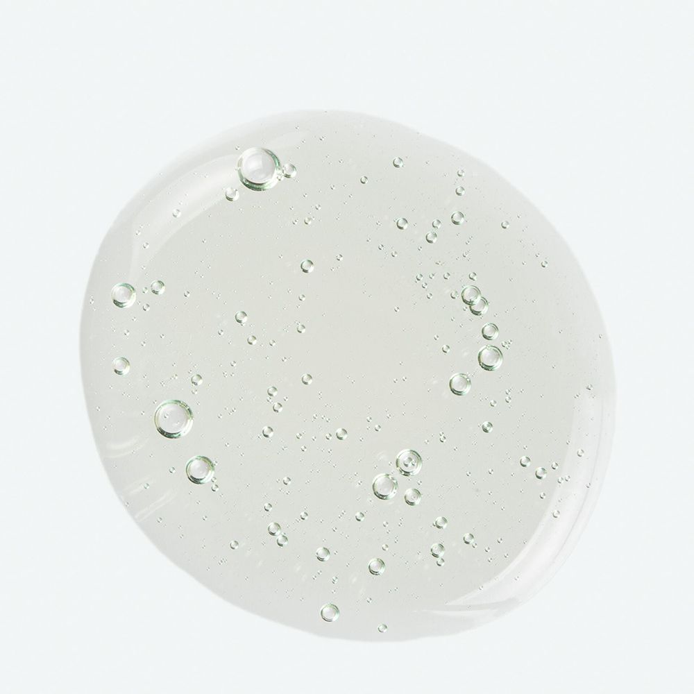 Liquide transparent ovale avec petites bulles. Sur fond clair.