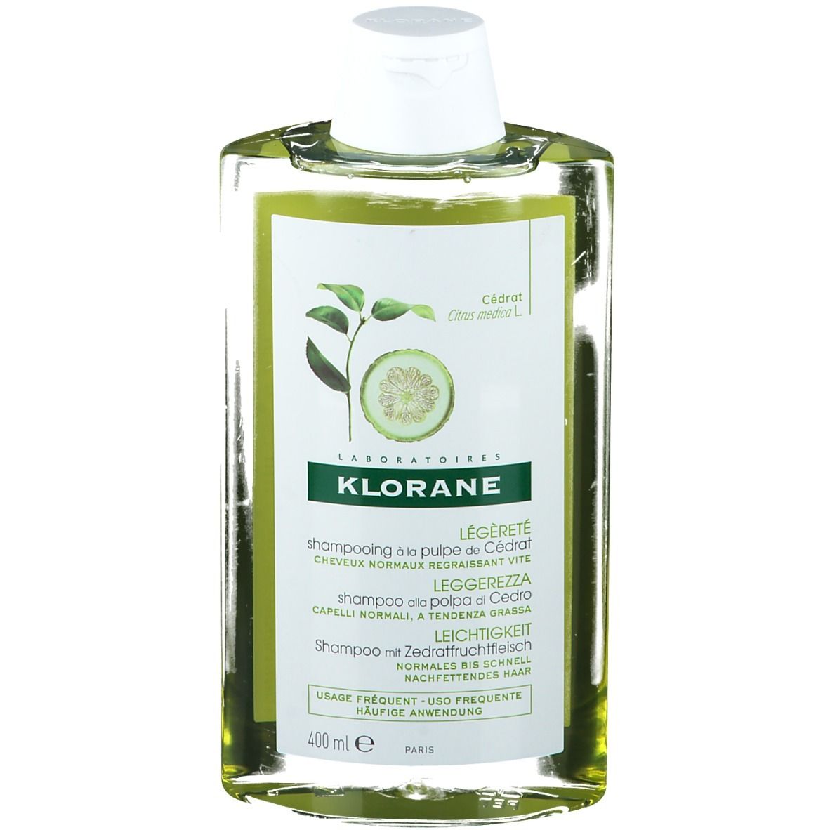 Flacon de shampooing transparent avec étiquette verte. Inscription : KLORANE, extrait de citron. Bouchon blanc. 400 ml.