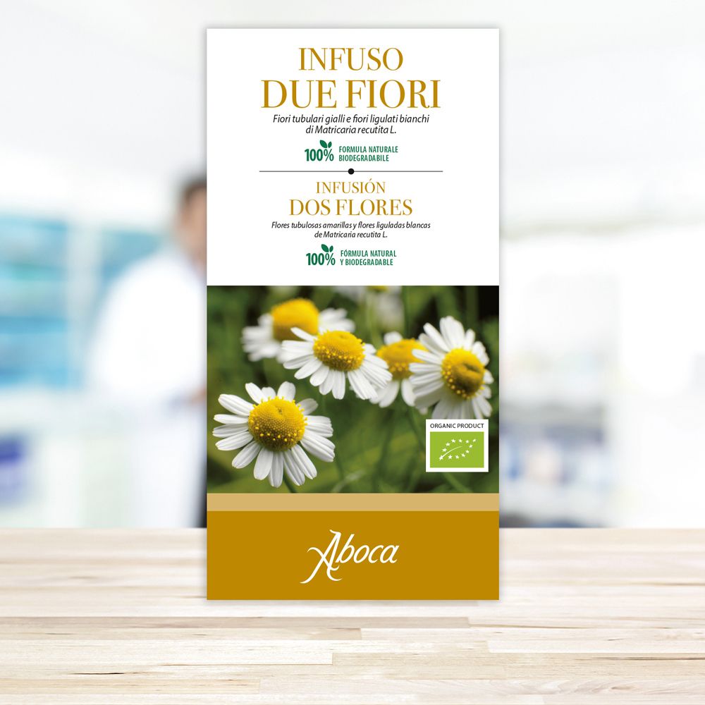 Aufrechte Verpackung mit Aufdruck. Aufschrift "Infuso Due Fiori". Bild von Kamillenblüten. Marke "Aboca". Bio-Siegel.