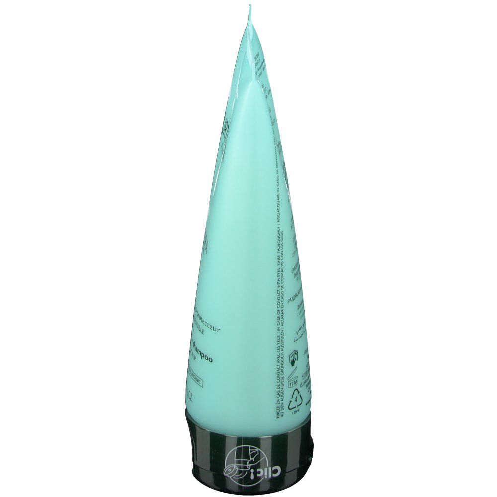 Tube de shampooing bleu clair, vue latérale. Bouchon noir. Texte sur le tube.
