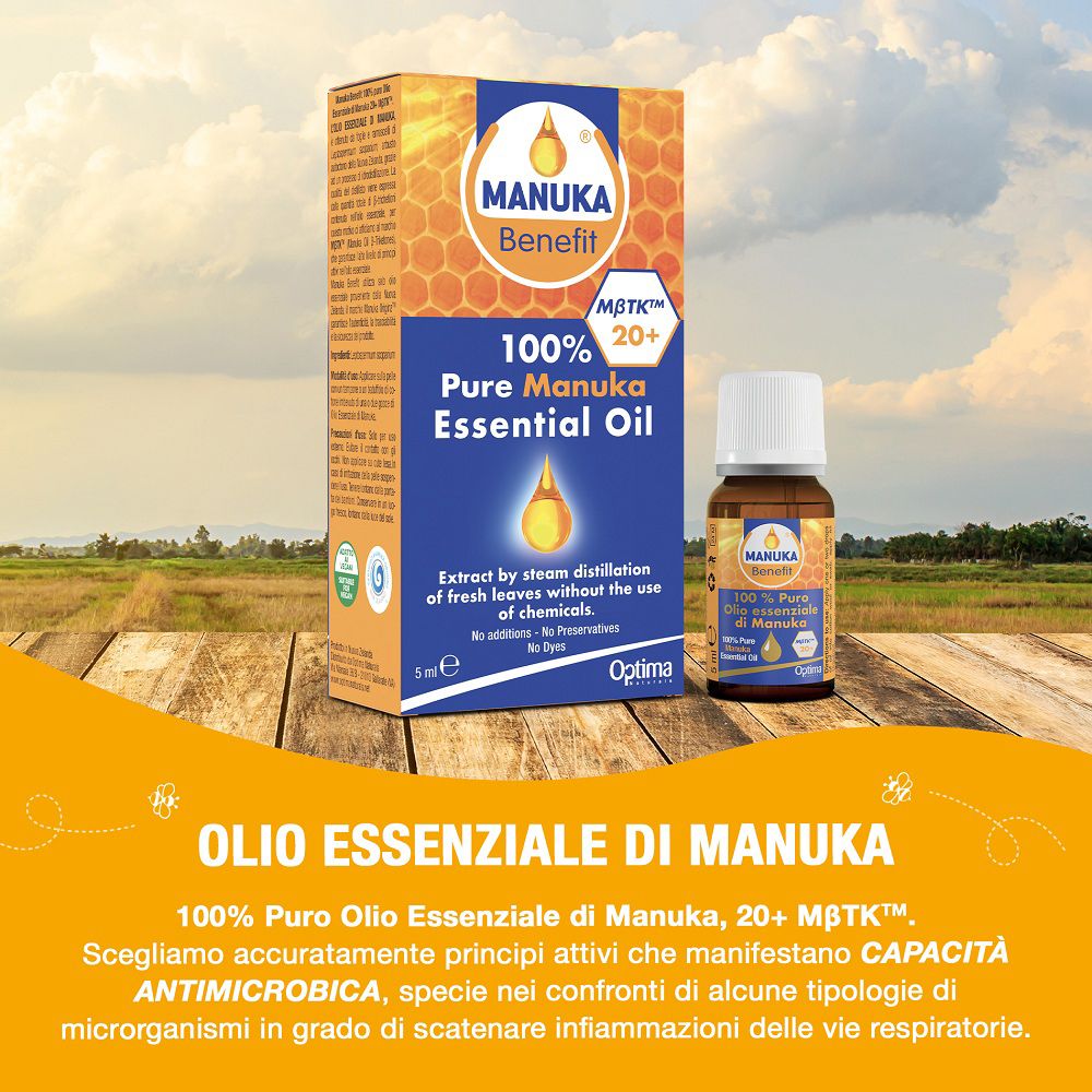 MANUKA Benefit Ätherisches Öl auf Holztisch, mit ländlicher Kulisse.