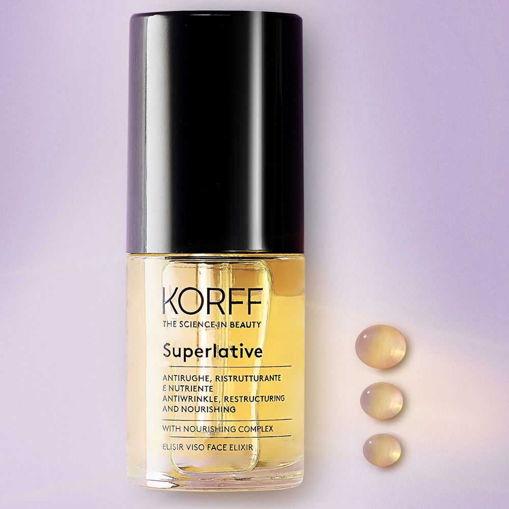 Élixir facial KORFF Superlative. Flacon noir. Liquide jaune et gouttes visibles.