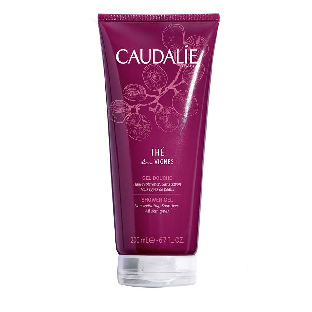 Tube de gel douche rouge foncé. Inscription CAUDALIE, Thé des Vignes. Texte: Gel Douche, Shower Gel. Bouchon blanc.