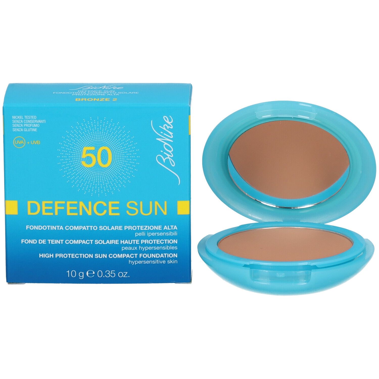 Fond de teint compact et emballage. Boîtier bleu clair ouvert, poudre brune. Boîte bleue avec texte.