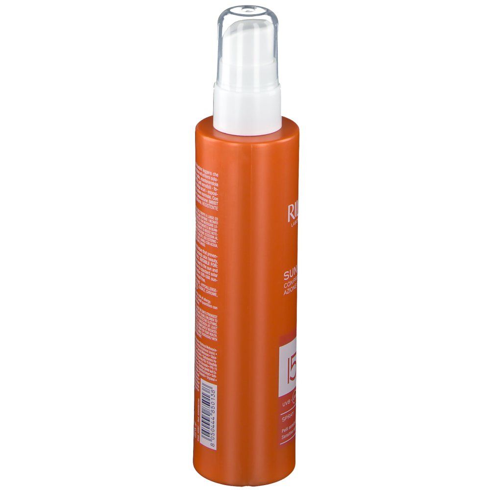 Flacon spray orange avec tête blanche. Texte: Rilastil, Sun System, SPF 15. Vue latérale avec informations produit.