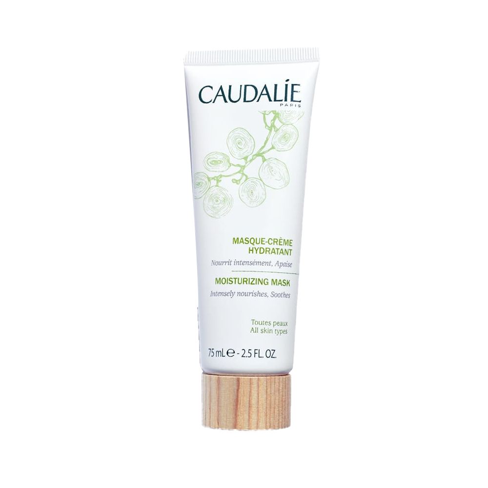 Weiße Tube mit grünem Aufdruck. Text: CAUDALIE, MASQUE-CRÈME HYDRATANT, MOISTURIZING MASK. Holzfarbener Boden. 75 ml.