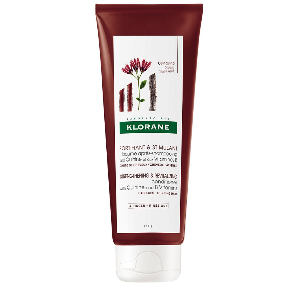 Tube marron avec étiquette blanche. Texte: KLORANE, FORTIFIANT & STIMULANT, avec Quinine et Vitamines B. Illustration: plante à fleurs rouges.