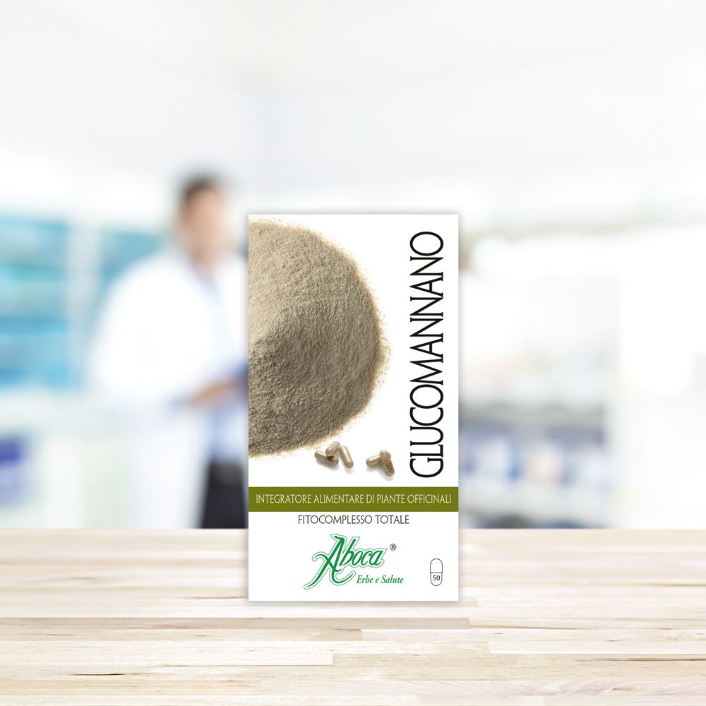 Emballage du produit sur table en bois. Inscription : Glucomannano, Aboca. Arrière-plan : pharmacie floue.