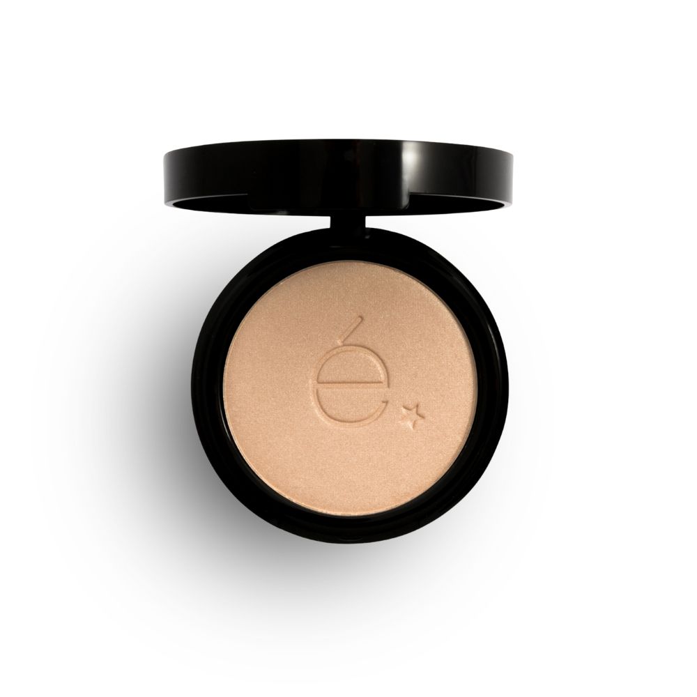 Boîtier cosmétique rond noir ouvert, poudre claire. Logo étoile gravé. Vue de dessus.