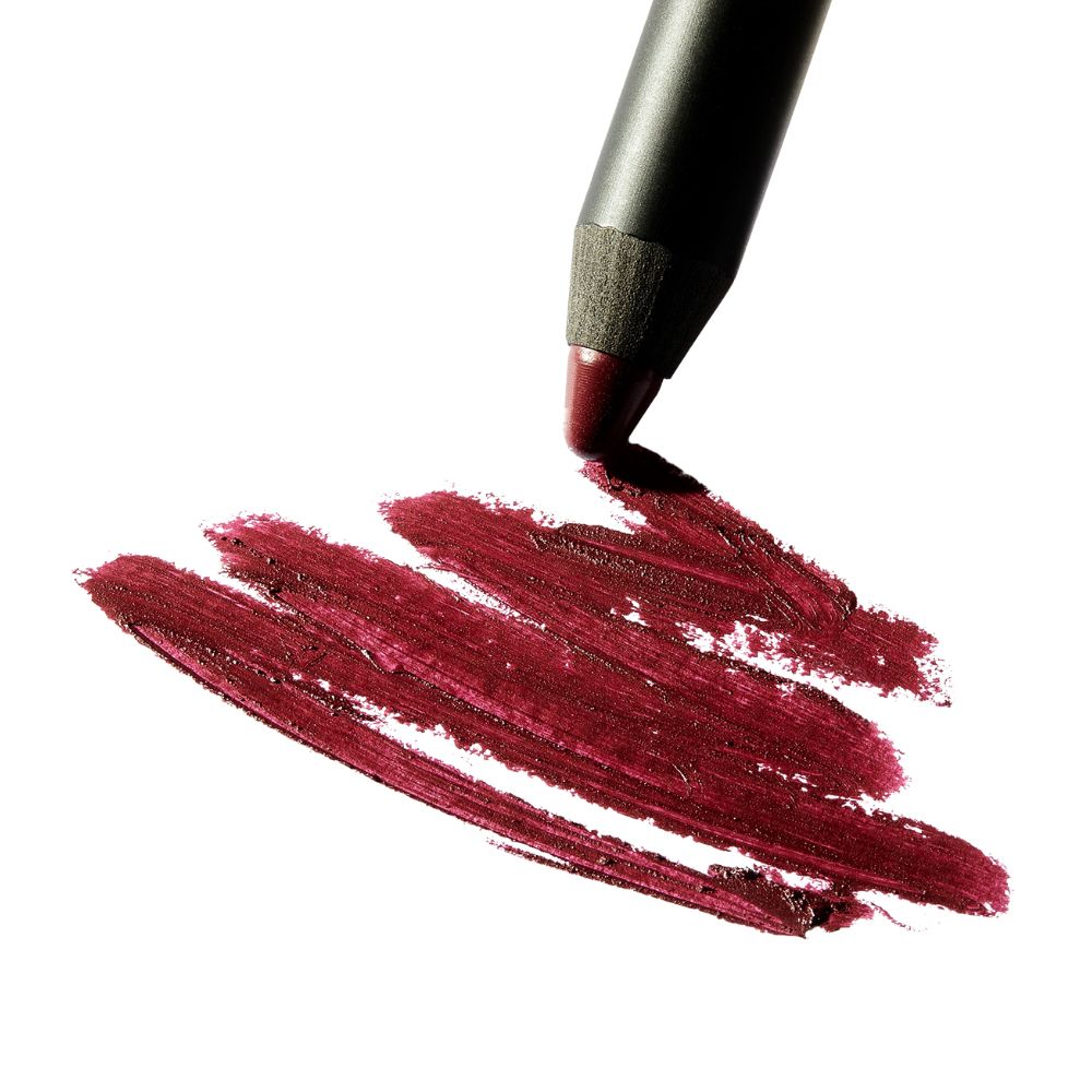 Crayon rouge à lèvres traçant des traits. Rouge à lèvres bordeaux sur fond blanc. Texture visible.