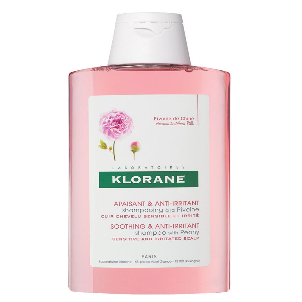 Klorane Shampoo-Flasche, rosa Flüssigkeit, weißer Deckel. Etikett mit Pfingstrose und Text.