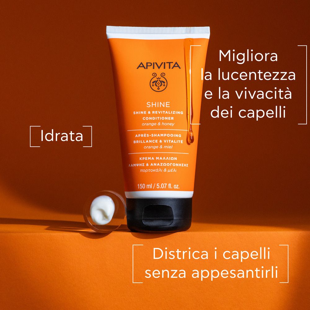 Tube orange avec bouchon blanc. Inscription: APIVITA SHINE Revitalisierender Conditioner. Texte: Idratata, Districa i capelli senza appesantirli.