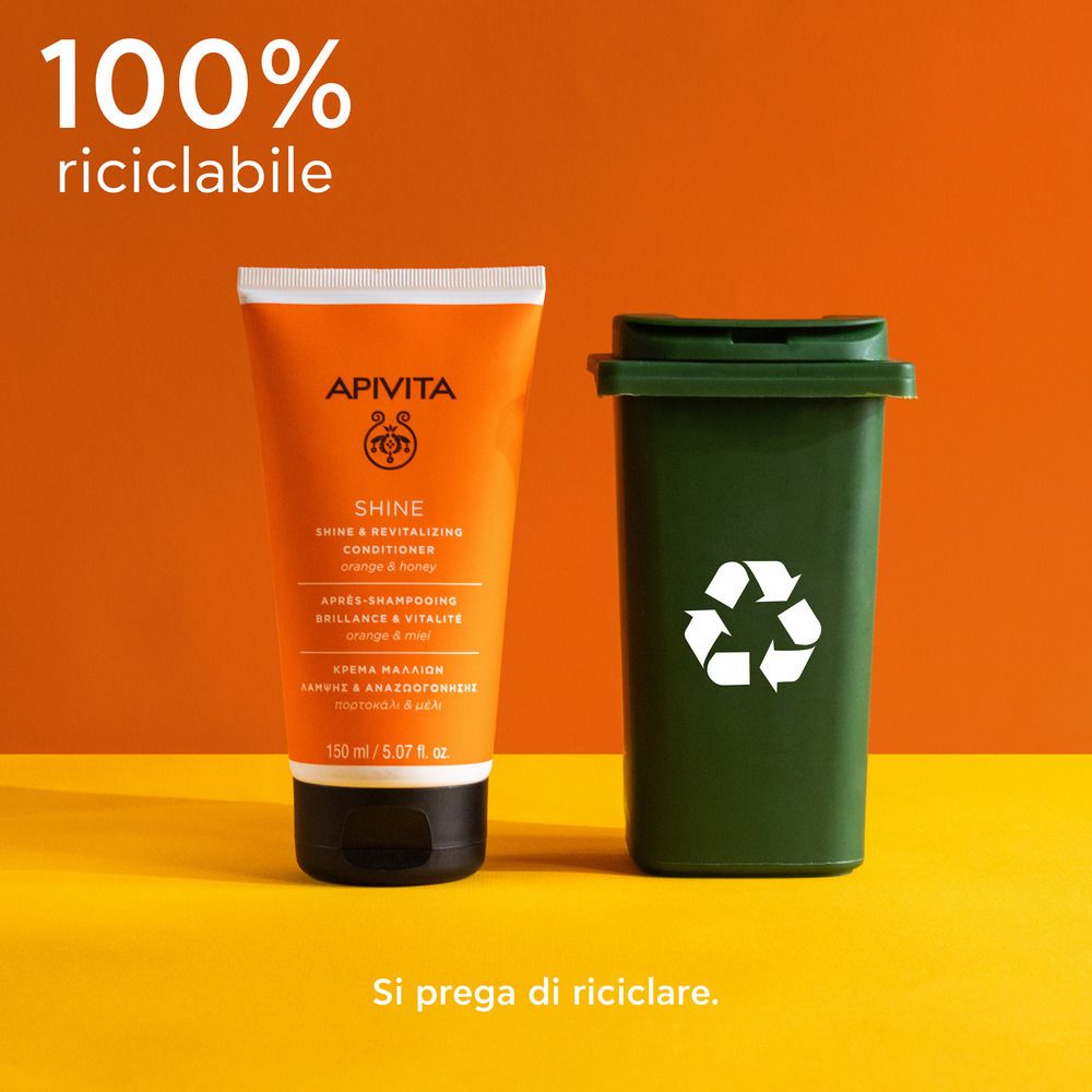 Tube orange à côté d'une poubelle verte. Inscription: APIVITA SHINE Revitalisierender Conditioner. Texte: 100% riciclabile.