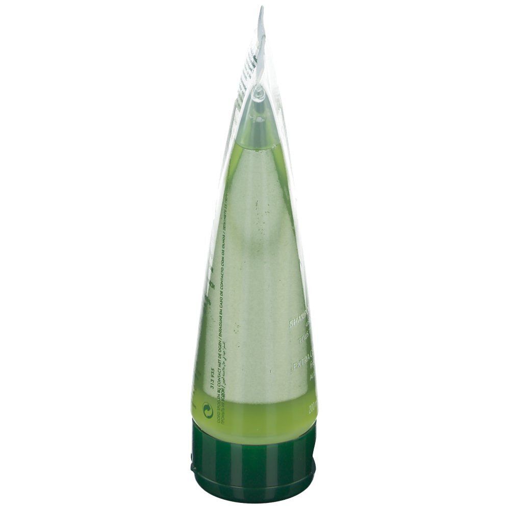 Tube transparent de shampooing. Bouchon vert. Vue latérale.