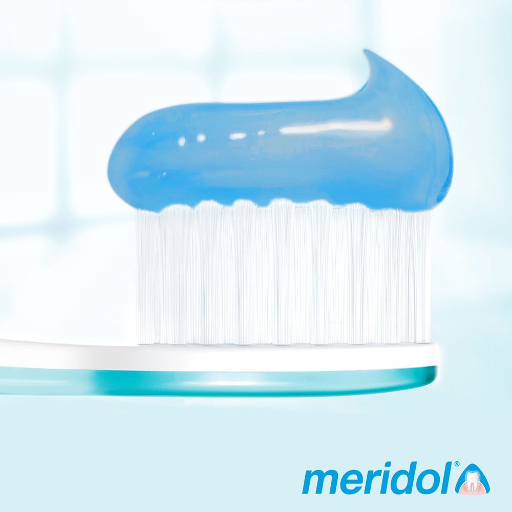 Brosse à dents avec filet de dentifrice bleu. Logo meridol.