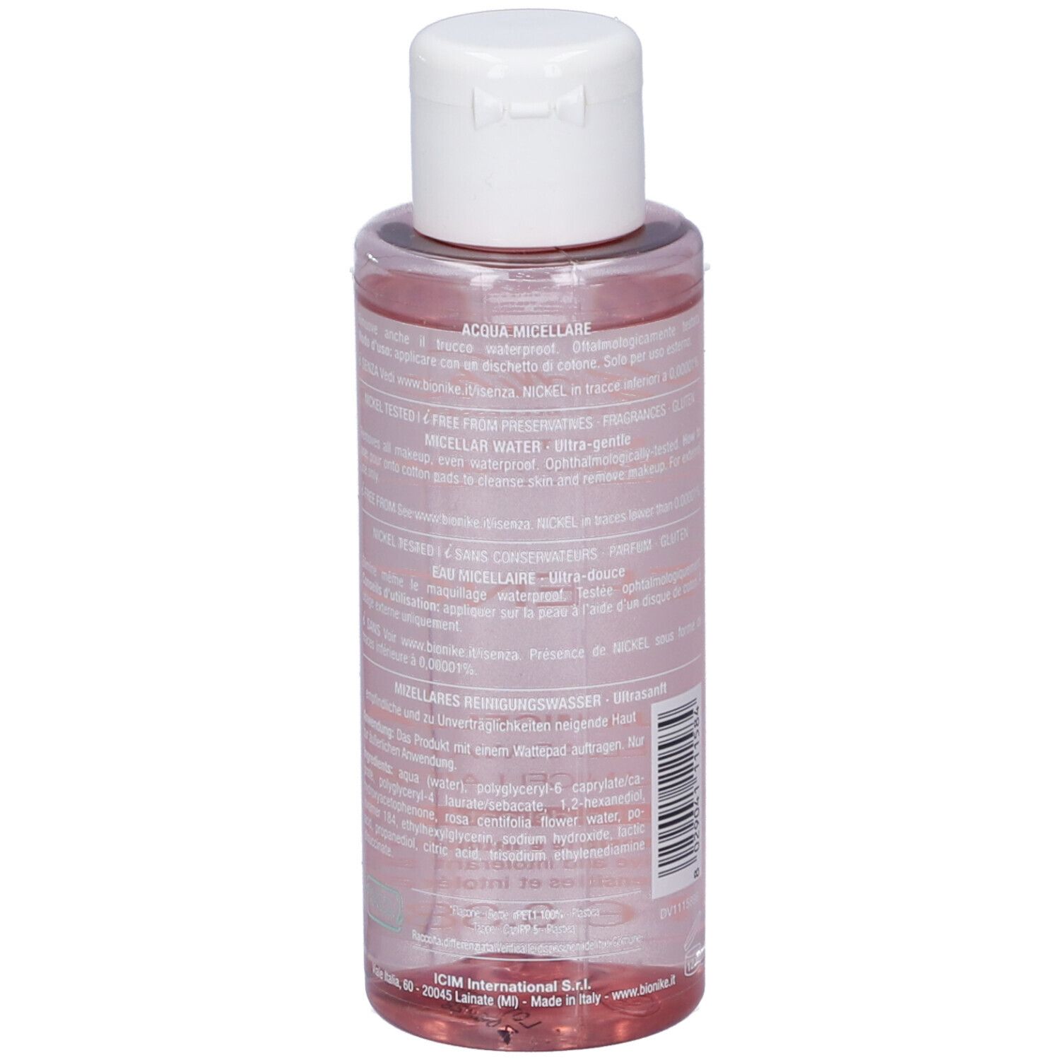 Dos du flacon. Texte multilingue. Flacon avec liquide rose. Bouchon blanc.