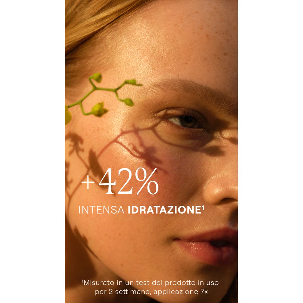 Gesicht einer Frau mit Schatten. Text: +42% intensive Feuchtigkeit. Hintergrund: Pflanzen.
