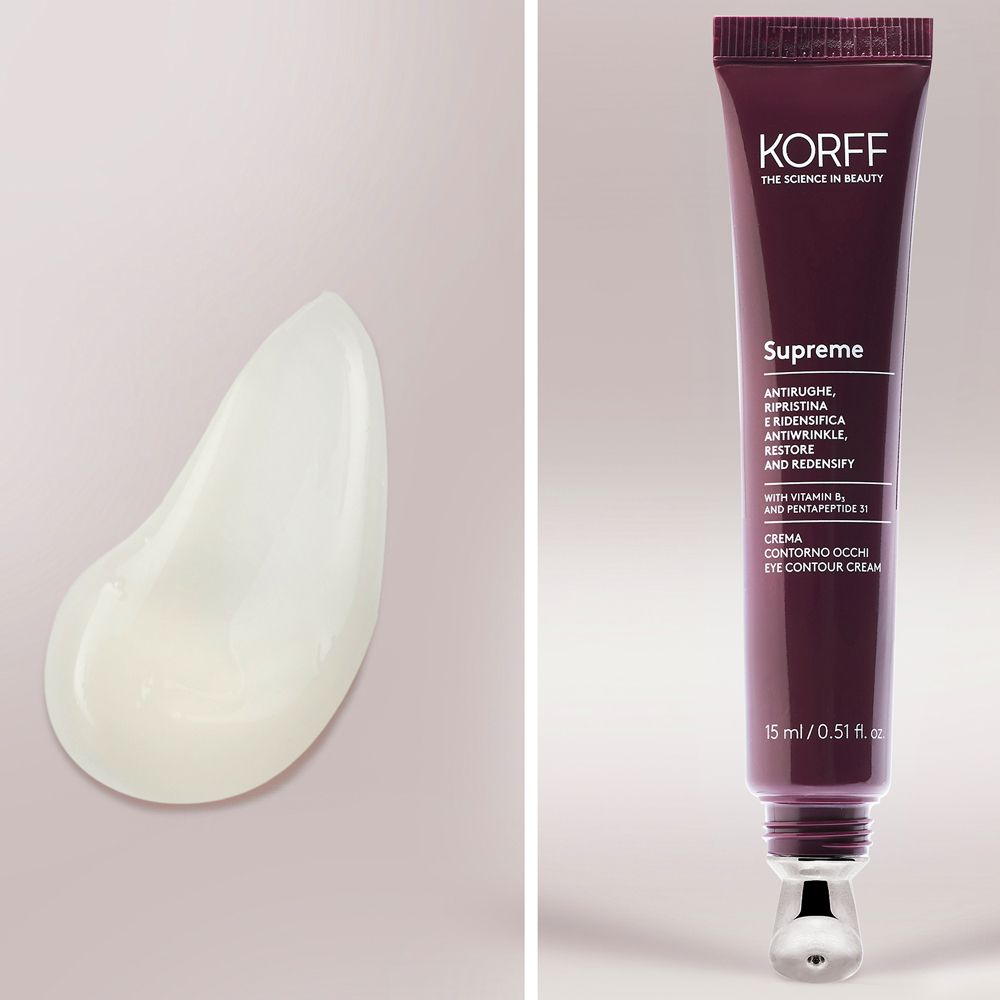 Tube de crème pour les yeux KORFF Supreme et goutte de crème. Tube rouge foncé, applicateur argenté. Goutte de crème blanche.