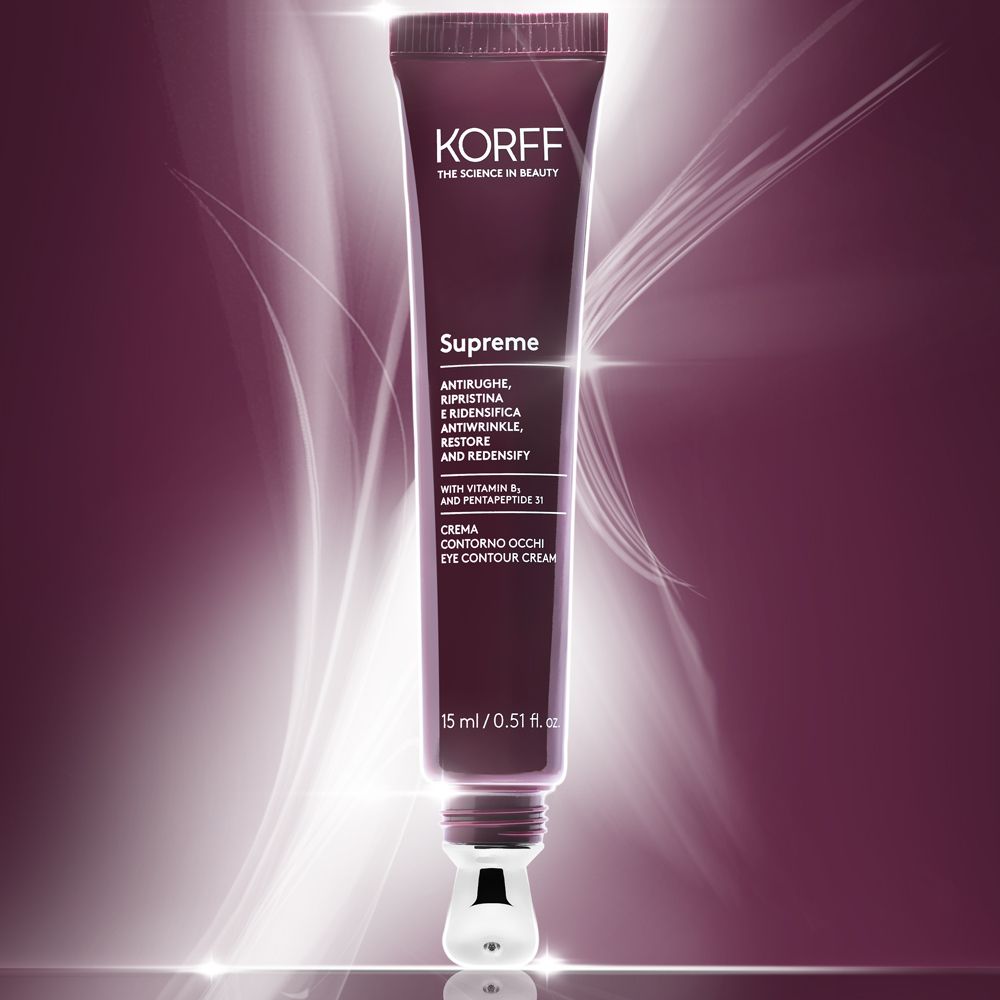 Tube de crème pour les yeux KORFF Supreme. Rouge foncé, applicateur argenté. Texte : anti-rides, redensifiant, avec vitamine B5. Effets de lumière.