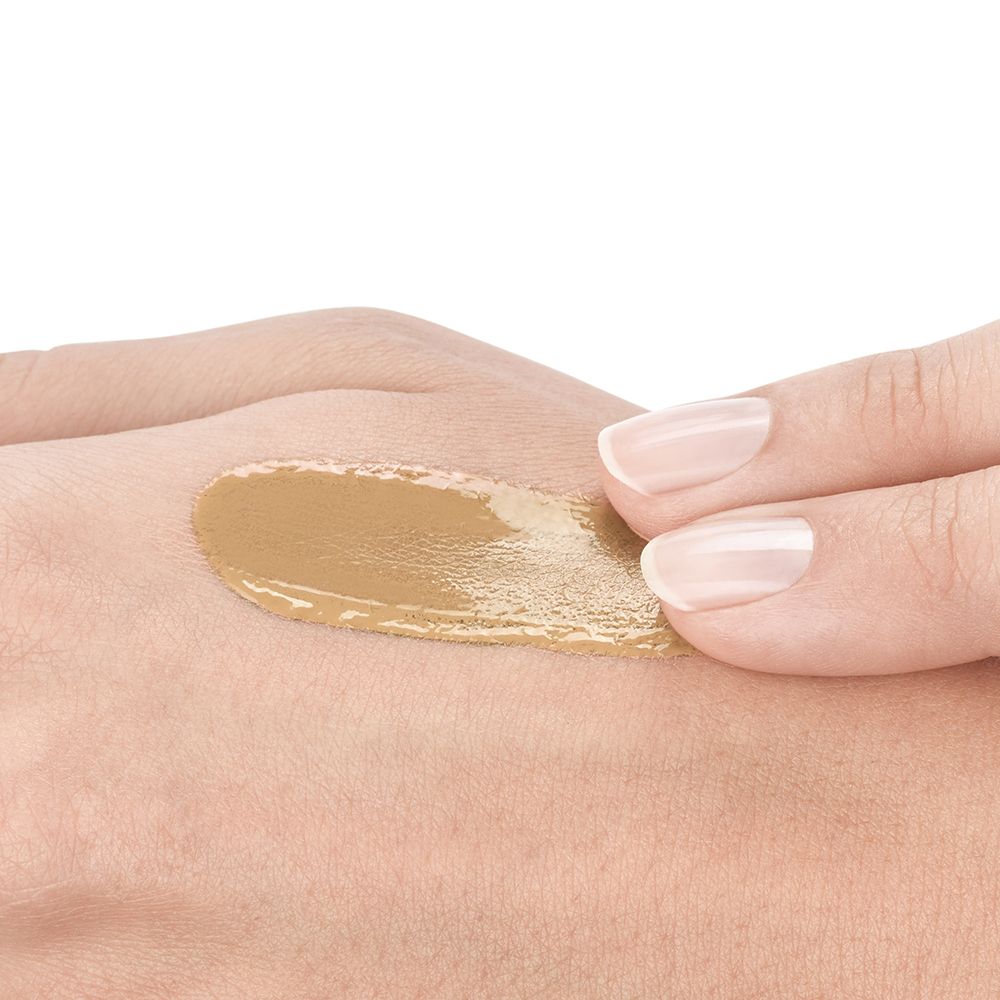Main avec trace de fond de teint. Peau claire, fond de teint beige. Aucune indication de produit visible.