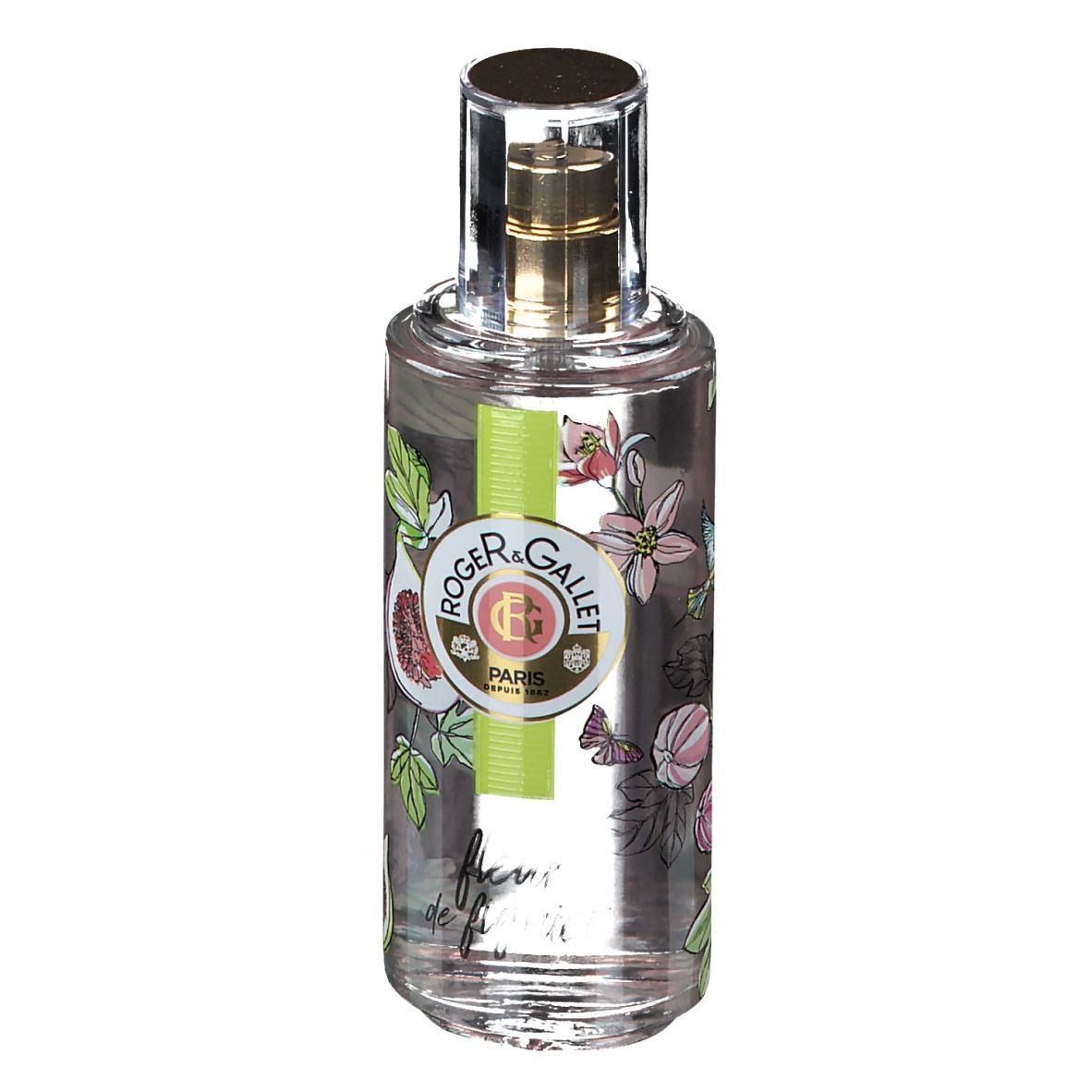 Flacon transparent avec vaporisateur doré. Étiquette avec figues, fleurs et logo. Bande verte et blanche avec logo.