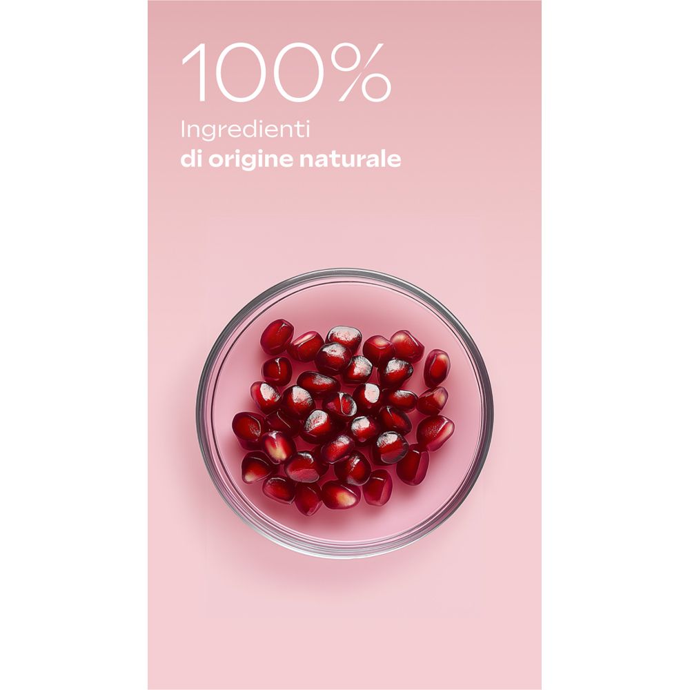 Rosa Hintergrund mit Glas Schale gefüllt mit Granatapfelkernen. Text: 100% Inhaltsstoffe natürlichen Ursprungs.