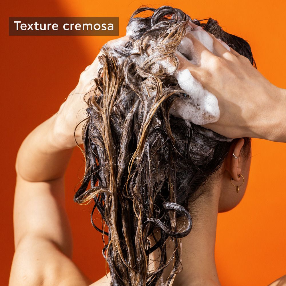 Mains lavant les cheveux avec du shampooing. Texte : Texture crémeuse.