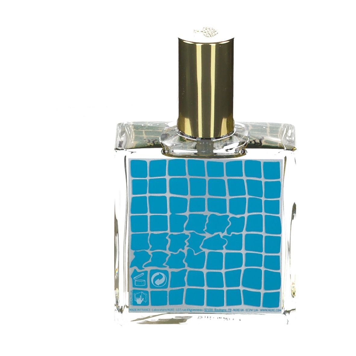 Flacon en verre transparent avec bouchon doré. Étiquette bleue avec motif carré et symboles.