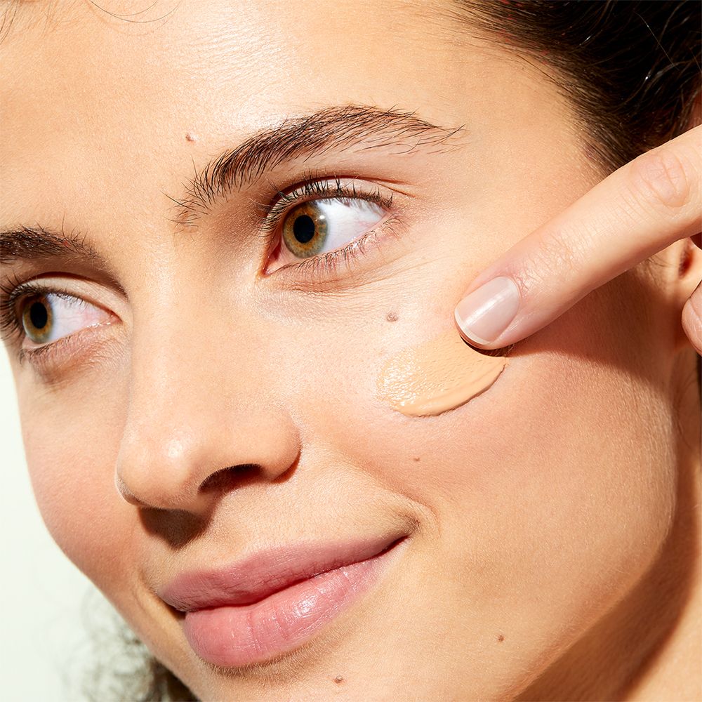 Personne montre un échantillon de couleur sur la joue. Inscription: NUXE BIO, Thé Blanc, White Tea, crème teintée. Pour peaux moyennes.