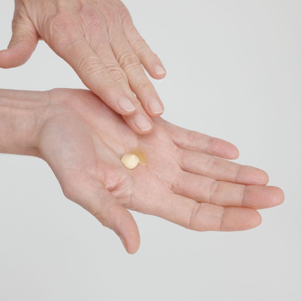 Mains avec une petite quantité d'huile. L'huile est répartie sur la paume.