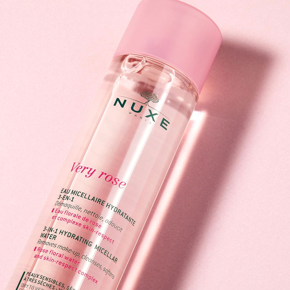 Flacon transparent incliné avec liquide rose et bouchon rose. Inscriptions: NUXE, Very rose.