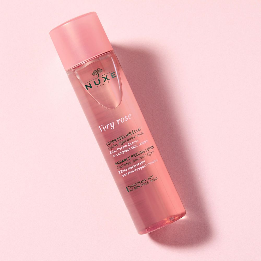 Schräg liegende rosa Flasche mit rosa Deckel. Aufschrift: NUXE, Very Rose, Lotion peeling éclat.