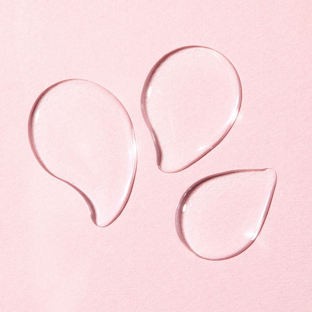 Drei transparente Tropfen auf rosa Hintergrund. Keine Beschriftung sichtbar.
