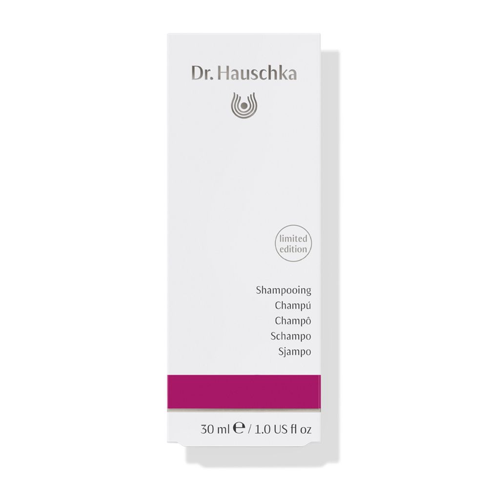Weiße Schachtel mit lila Band. Aufschrift: Dr. Hauschka, Shampoo, limited edition. 30 ml.