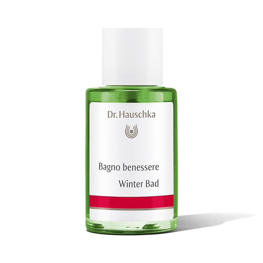 Flacon en verre vert avec bouchon blanc. Étiquette avec logo Dr. Hauschka et texte: Winter Bad. Bande rouge en bas.