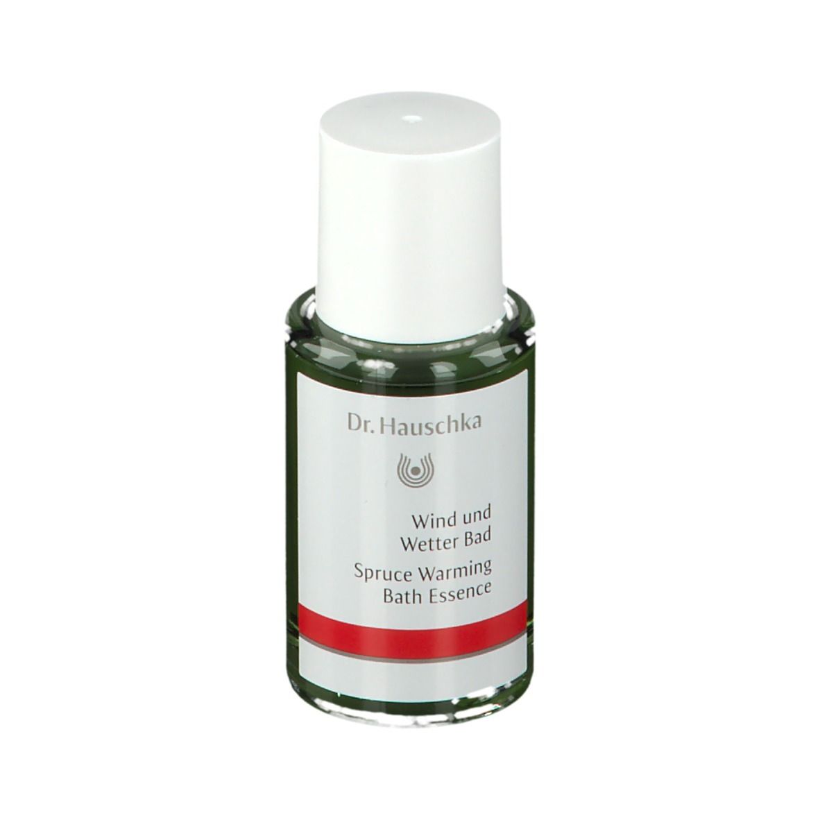 Flacon en verre vert avec bouchon blanc. Étiquette avec logo Dr. Hauschka et texte: Wind und Wetter Bad, Spruce Warming Bath Essence.