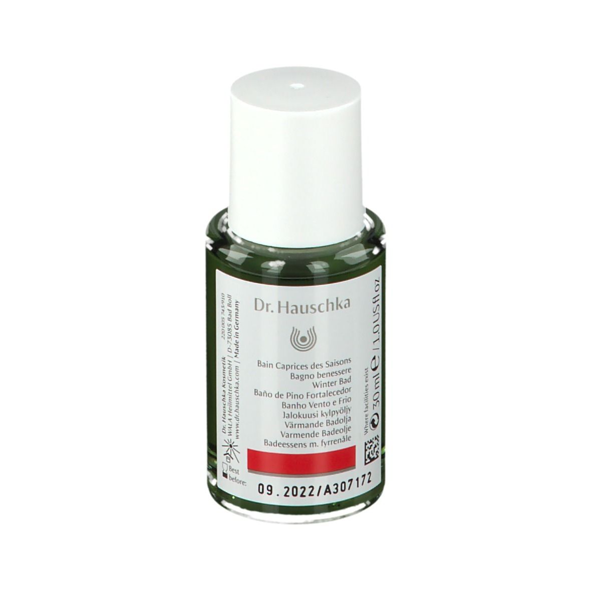 Flacon en verre vert avec bouchon blanc. Étiquette avec logo Dr. Hauschka et texte: Wind und Wetter Bad, Spruce Warming Bath Essence.