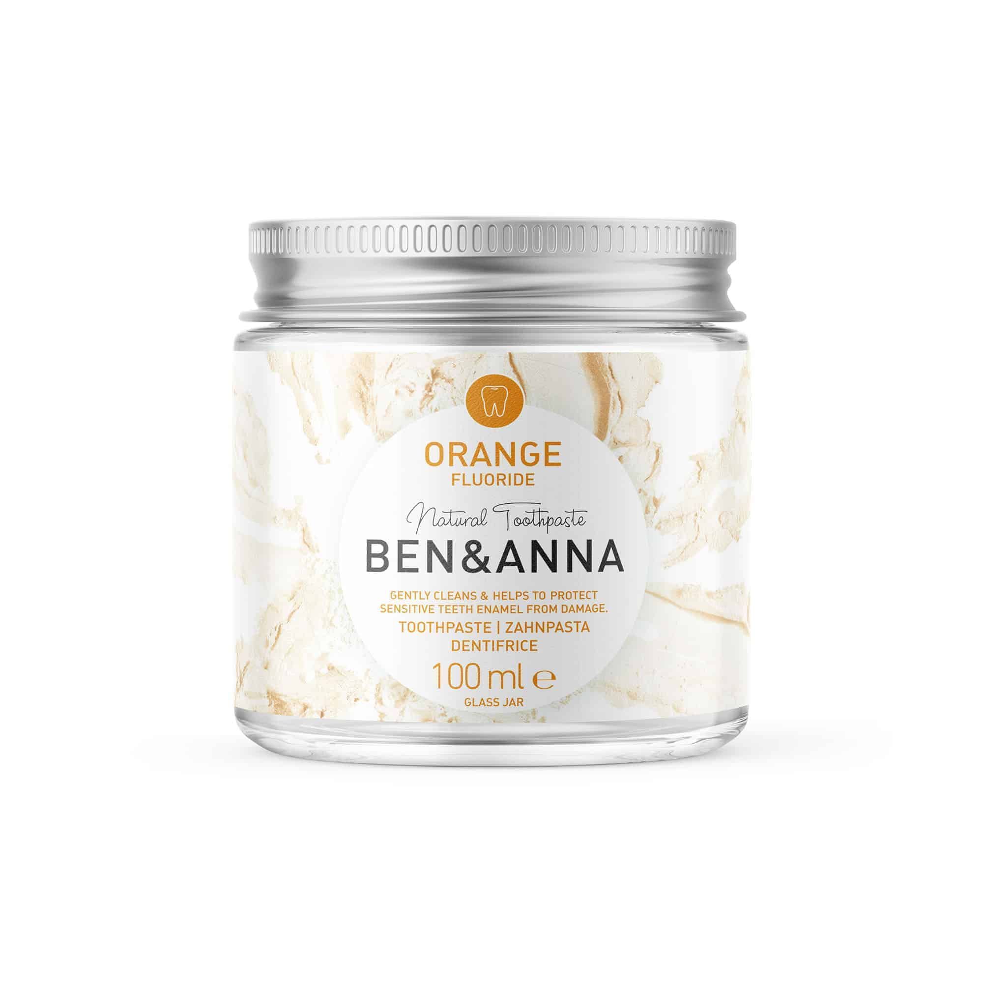 Dentifrice en pot de verre, couvercle argenté. Étiquette avec texte Orange, Fluoride, Ben & Anna, dentifrice, 100 ml.