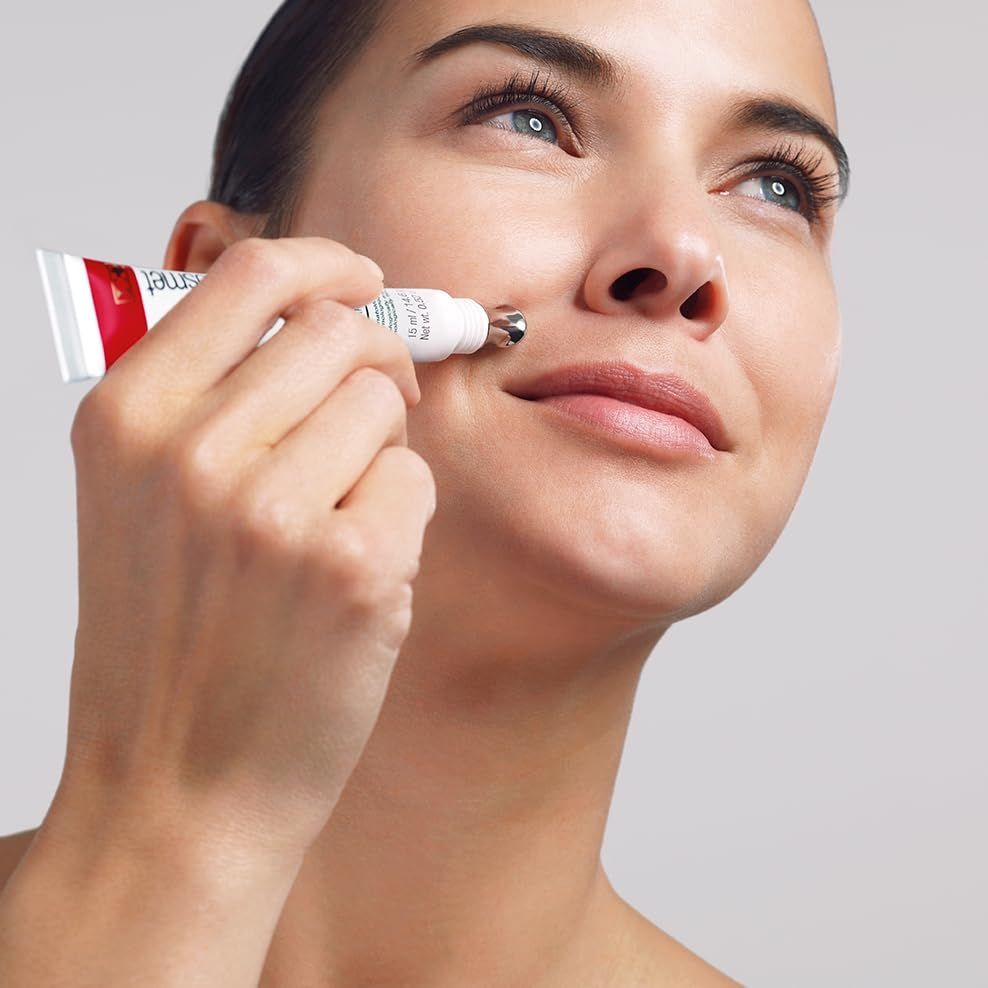 Femme tenant Cellfiller-XT. Tube avec applicateur appliqué sur la peau. Fond gris.