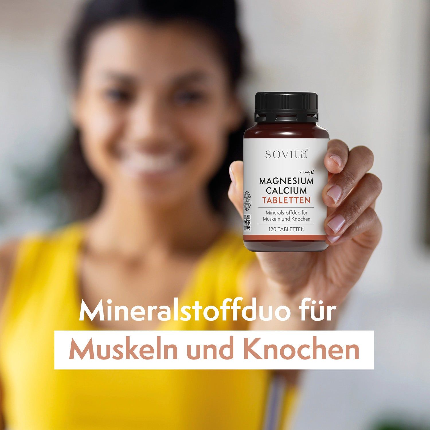 Femme tenant un flacon de SoVita® Magnesium Calcium Tabletten. Texte: Mineralstoffduo für Muskeln und Knochen. Haut jaune.