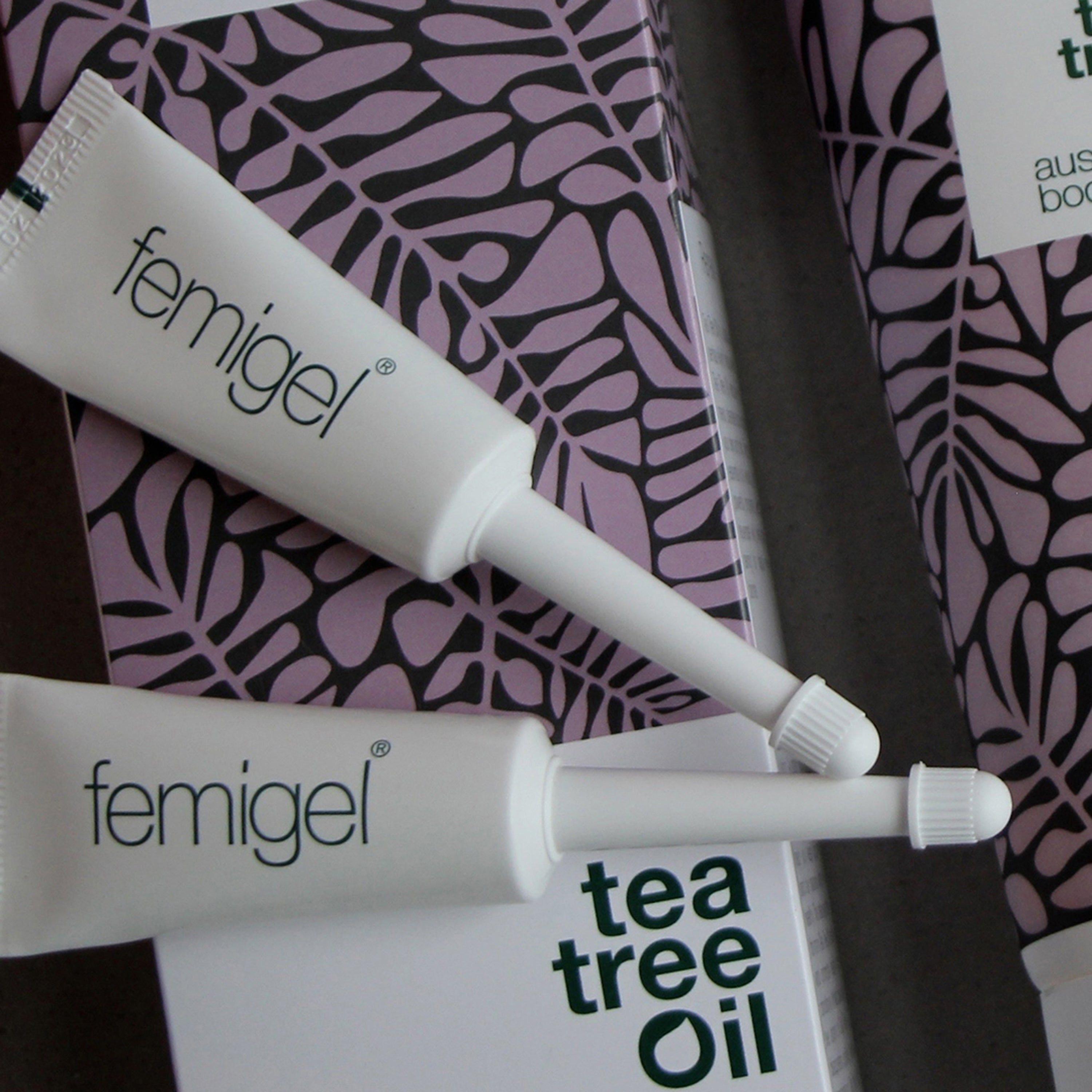 Deux tubes Femigel avec applicateur. Emballage à motif de feuilles en arrière-plan. Texte : Femigel, Tea Tree Oil.