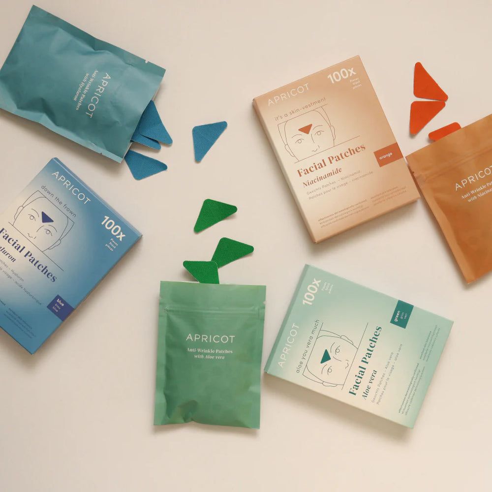 Divers emballages et sachets de patchs faciaux APRICOT. Patchs triangulaires de différentes couleurs. Texte: 100x.