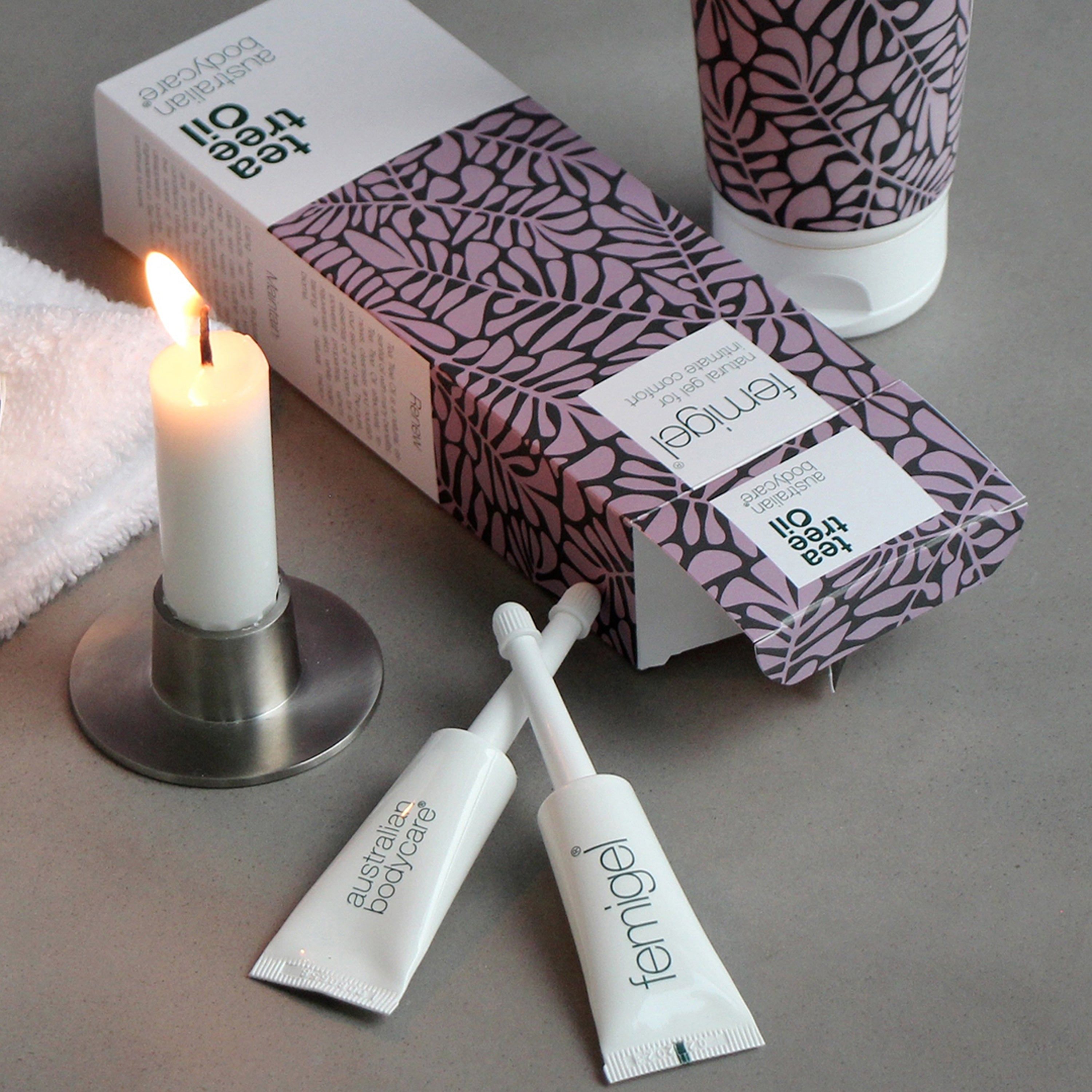 Deux tubes Femigel avec applicateur, bougie, emballage. Emballage avec motif de feuilles. Texte : Femigel, Tea Tree Oil, Australian Bodycare.