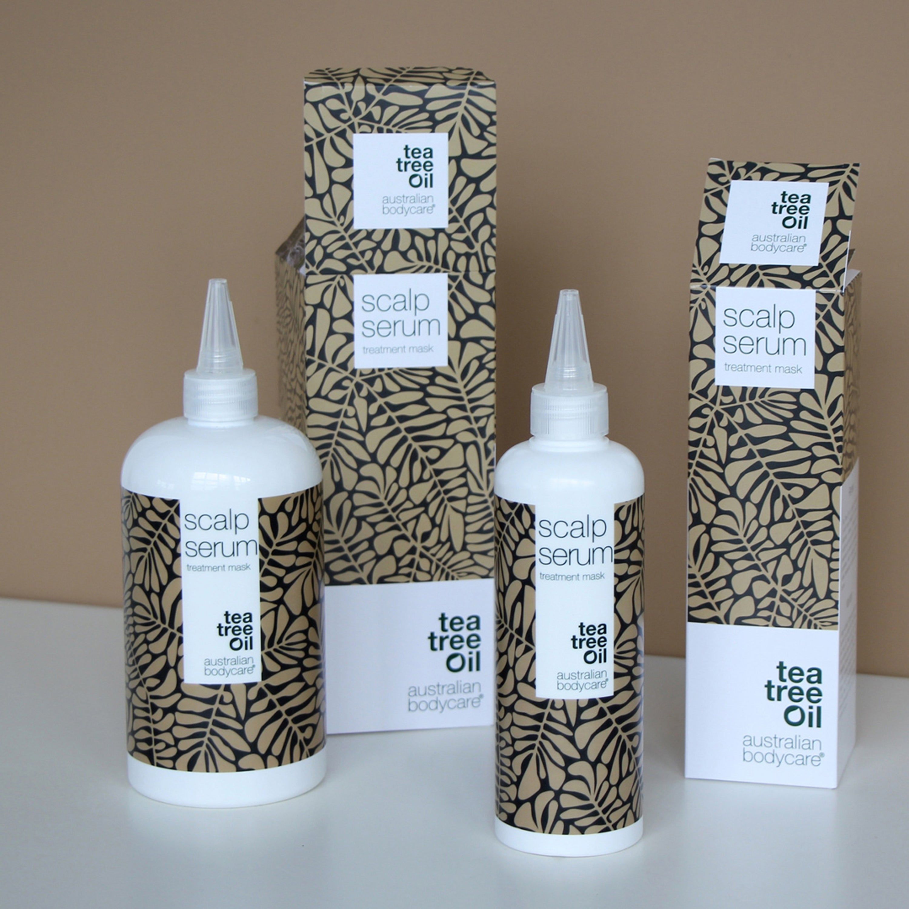 Trois flacons de sérum et emballages. Inscription : Scalp Serum, tea tree oil, australian bodycare.