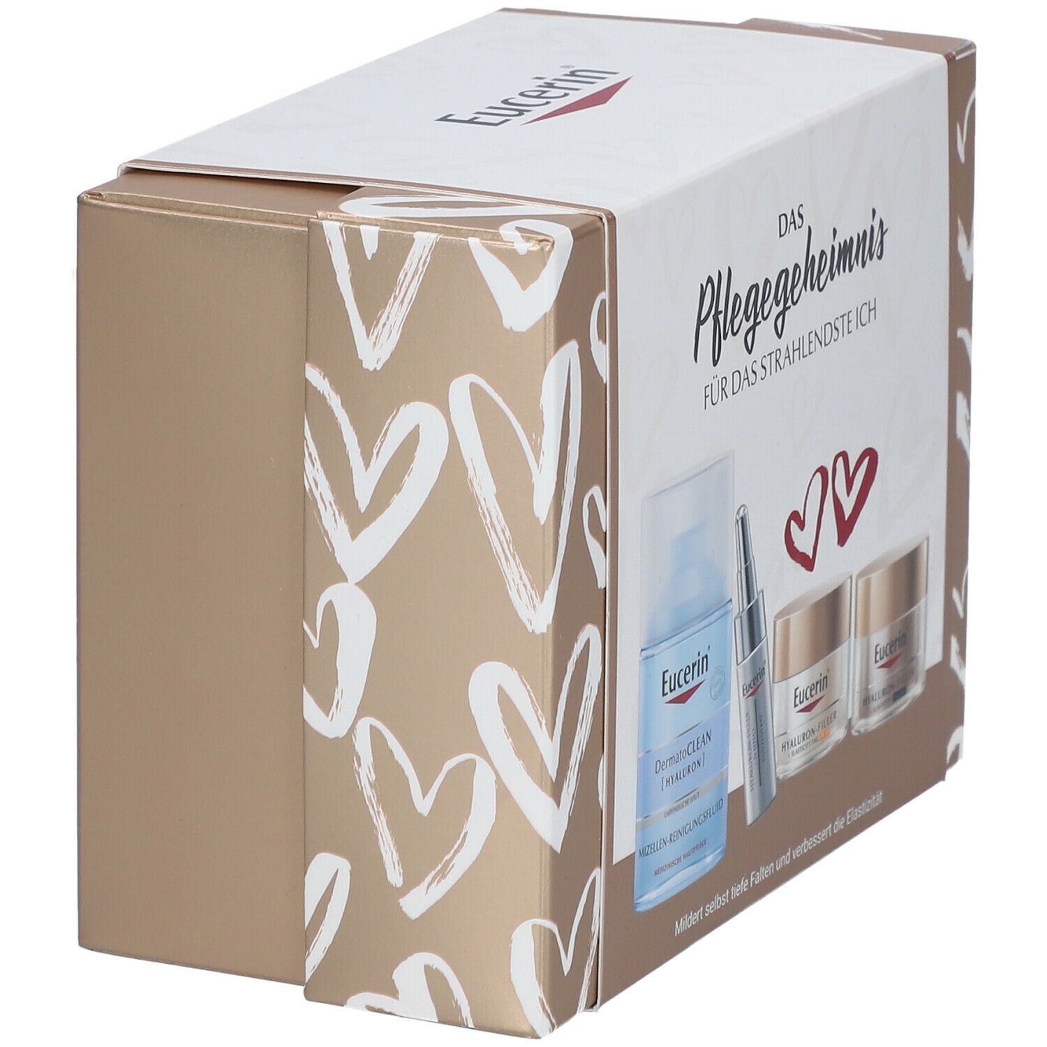 Coffret cadeau Eucerin. Contient une bouteille, un sérum et des crèmes. Motif de cœurs blancs sur fond beige doré. Vue en biais.