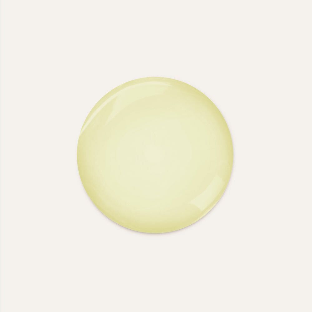 Tache ronde jaune sur fond clair. Probablement un échantillon de shampooing.