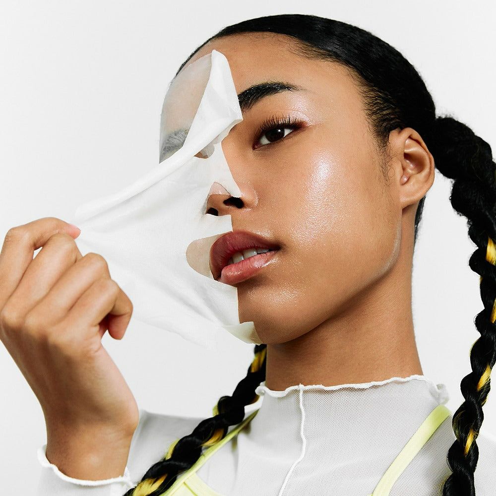 Eine Frau entfernt eine Gesichtsmaske. Gesichtshälfte mit Maske, andere ohne. Haut ist sichtbar.