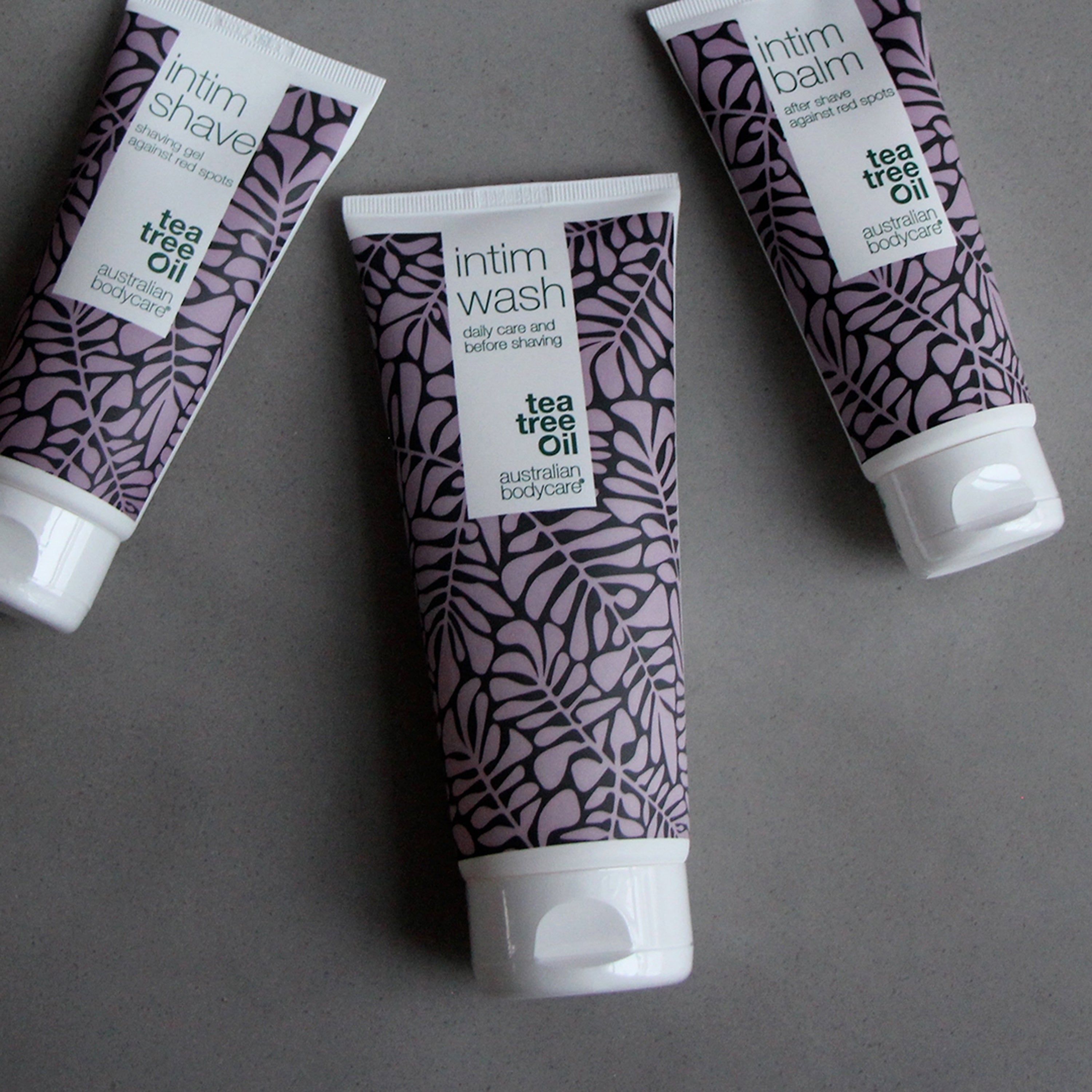 Trois tubes. Inscription : Intim Wash, Intim Shave, Intim Balm. Marque : Australian Bodycare. Motif de feuilles violet.
